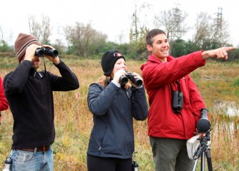 Brian Cocca (left) and Liverpool Middle School math teacher Sara Pieklik (center) spot birds.  In total, 28 species were observed during the 3-hour event.