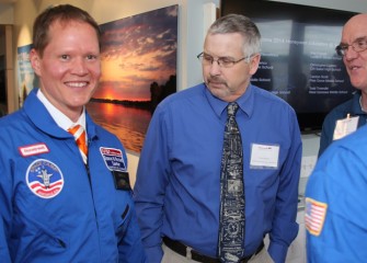 Central New York Space Academy alumni Brian Ramsden (2013, center) and Dan Howard (2012, right) admire West Genesee Middle School teacher Todd Troendle's new flight suit.