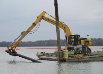 An old cast iron pipe is removed from the lake.