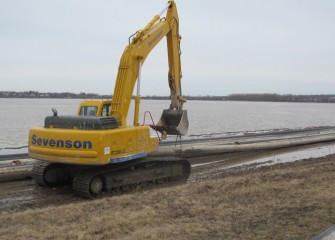 Pipe used in capping operations is lined along the shore before placing in the lake.
