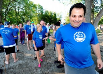 John DeSantis (right), President of Believe in Syracuse, leads the way to boats carrying swimmers out to the platform.