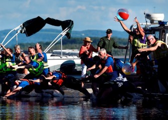 Community members and elected and appointed officials jump and dive into the lake.