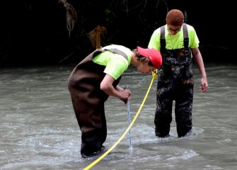 Michael Pellizzari (left), from Solvay, and Shakeem Ellick, from Westside Academy at Blodgett in Syracuse, take measurements in Onondaga Creek.