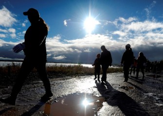 Rain and wet snow earlier in the morning clear just as volunteers head out along the western shoreline to plant trees and observe birds.