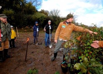 Tony Eallonardo, Ph.D., scientist in plant ecology and ecosystem restoration at O’Brien & Gere, shows volunteers the variety of trees they will plant.