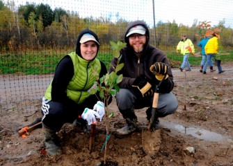 Stacey Keefe and Ben Larsen, of North Syracuse, plant a black chokeberry (Aronia melanocarpa), native to the Great Lakes region. The black chokeberry will eventually produce abundant rich berries that serve as food for wildlife and birds such as Ruffed Grouse.