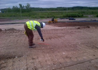 A worker prepares to test compaction of the leveling layer, which averages four feet thick.