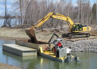 Capping material is loaded into a barge at Nine Mile Creek for placement in the lake.