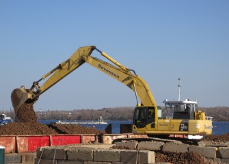 Coarse gravel is loaded on a barge for mechanical capping. Capping operations will continue as late as possible in the fall and resume in spring 2016.