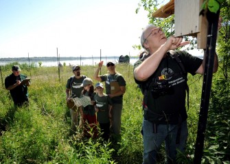 Onondaga Lake Conservation Corps volunteer Douglas Beauchamp inspects a nest box installed last year, while the Keefe family observes birds in the area and Steve Mooney helps records data.