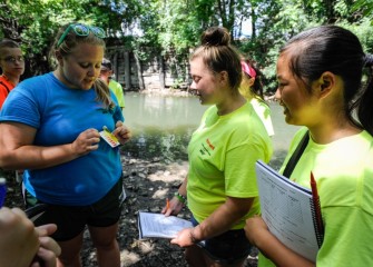 Students Maggie Muldoon (center) and Julia Commane (right), from Liverpool School District, learn how to measure the water’s pH using test strips.