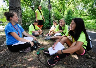 Working in teams during the week students record observations in notebooks as they take measurements and observe the natural world.