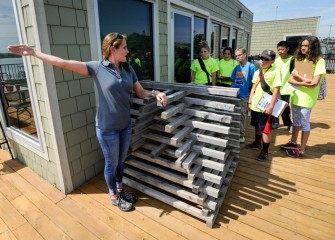 Anne Burnham, Associate Scientist at Parsons, shows students a “porcupine crib,” a structure that will be sunk into the lake to provide additional fish habitat.