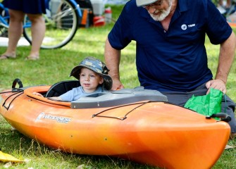 Sixteen-month old Christopher takes a ride in a kayak on land with his grandfather Charles Bertuch, of Syracuse.