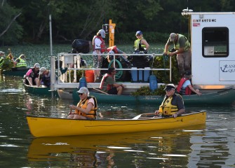 Nancy and Walt Shepard (foreground), from Fayetteville, head back for another load of plants. Some participants brought their own canoes and kayaks to help.