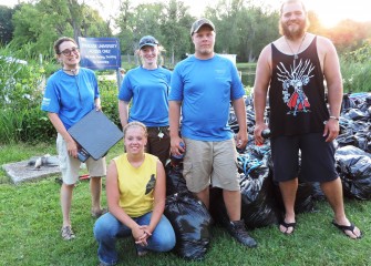 Members of Finger Lakes PRISM, the Partnership for Regional Invasive Species Management, took part in the water chestnut pull. Michelle Henry, left, holds a scale used to weigh bags of water chestnut.