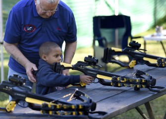 Onondaga County Federation of Sportsmen volunteers coordinate efforts among a number of local clubs to promote their outdoor sporting disciplines. Here 5-year-old Mason Wright learns how a crossbow works.