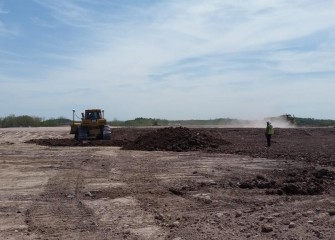 After settling over winter, work to regrade the leveling layer with additional soil begins.