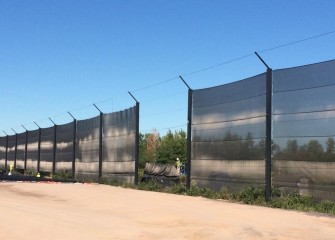 Workers remove sections of windscreen along the north side to make access for the cover construction.