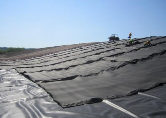 A layer of geotextile is laid on top of the leveling layer as a cushion and additional protection for the liner. The polyethylene liner is placed on top of the geotextile.