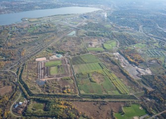 Grasses and vegetation are growing on the covered consolidation area, visible to the left of the sustainable Shrub Willow Farm (center). Both are built on Honeywell property in Camillus.