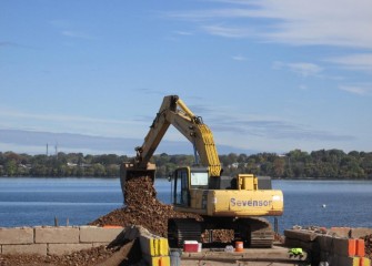 Barges are loaded with stone for placement in the lake.