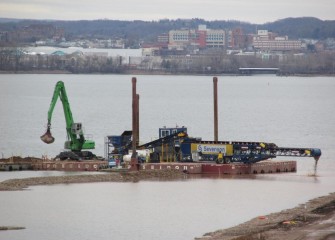 Capping material is placed inside the new wetland area connected to the Western Shoreline.