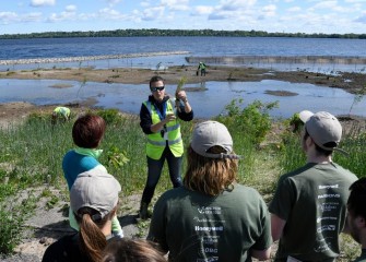 An environmental engineer with Parsons, Natalia Cagide-Elmer, explains proper planting procedures and goals for the day.