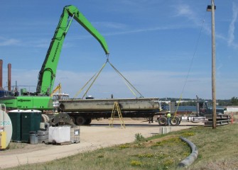 Sections of barges no longer needed are transported by flatbed truck. Shallow area capping continues.