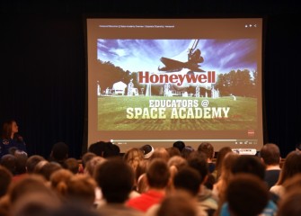 Students at Liverpool Middle School watch a video about Honeywell Educators @ Space Academy during an assembly.