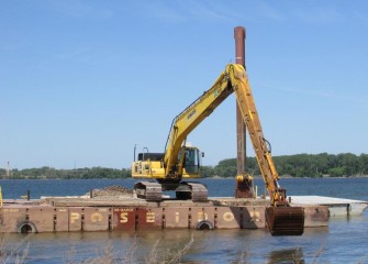 Gravel is added mechanically to the lake bottom close to shore.