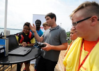 On Friday, Honeywell Day, environmental engineer Michael Smith (center) shows students operation of the Z-boat from the deck of the Onondaga Lake Visitors Center.