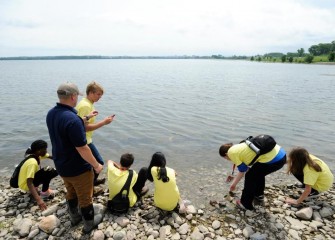 Students sample water along the Onondaga Lake shoreline.