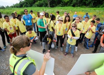 Jessica Saville, associate scientist at Parsons, shows before and after photos of the shoreline and describes the process of cleanup and restoration.