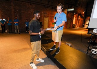 Yasin Hussan (left), from the Syracuse City School District, is presented an additional Certificate of Participation and Award of Distinction by his camp Science Counselor. Each counselor identified one student in his or her team for special recognition.