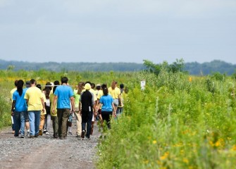 A group of students goes on a guided habitat walk in restored grassland, wetland, and shore areas along the western shoreline of the lake.