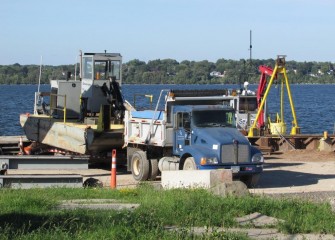 A support boat no longer needed in operations is removed from Onondaga Lake.