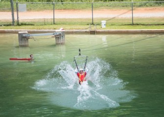 Van Buren Elementary School teacher Sarah Parrish splashes down on the water survival zipline.