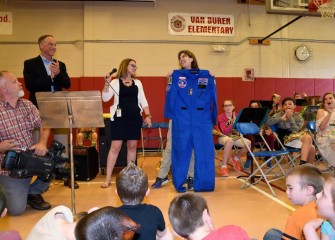 Teacher Sarah Parrish (center), selected to attend Honeywell Educators at Space Academy in 2017, is presented her flight suit at Van Buren Elementary School.