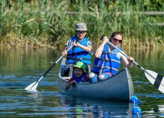 Pam Hartsell (front) and Liz Li, both of Fayetteville, give 6-year-old Jonah Hartsell a canoe ride.