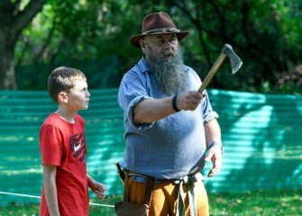 Ten-year-old Joey Cesario, of Auburn, learns how to throw a hatchet from New York State Muzzleloaders Association President Dan Fullington.