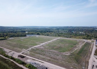 The cover system at the consolidation area consists of several feet of soil and a sealed liner to permanently encapsulate the geotextile tubes. Native grasses have been planted over the entire area.