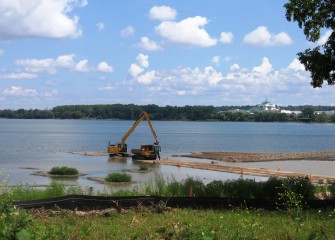 Topsoil is placed in shallow water areas, creating a habitat layer for underwater vegetation.