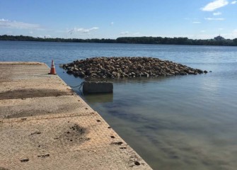 Construction of a berm along the southwestern shoreline begins.