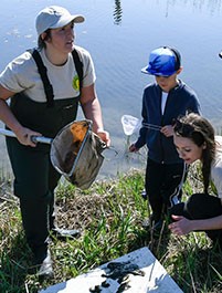 "The Young Naturalists Leadership Team creates opportunities to connect the Central New York community to conservation, restoration, environmental education, and stewardship projects," said Young Naturalists Leadership Team Project Coordinator Shannon Fabiani, pictured above, right, with Schermerhorn, helping 7-year-old Josh Gates (center) identify plant and animal species. "We are excited to work with the Onondaga Lake Conservation Corps to inspire environmental stewards throughout our community."