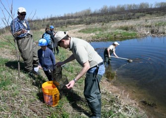 Seven-year-old Josh Gates watches as captured organisms are transferred into a bucket of water for further observation.