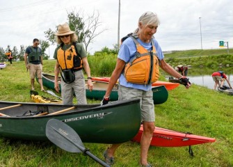 Ami Kadar (foreground), of Syracuse, a first-time Corps participant, prepares to launch her canoe.  Ami later said the experience was “wonderful, really beautiful” and that she took a lot of photos during the paddle.