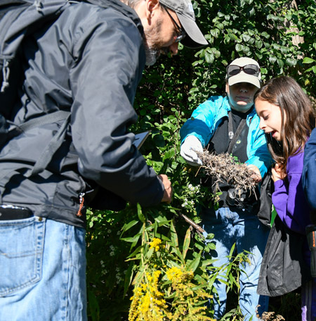 Ten-year-old Leah Jarrett (right), of Liverpool, inspects the contents of a nesting box previously installed along the western shoreline with her parents Cathy (center) and Rich Jarrett.