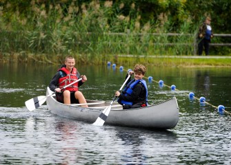 Cousins Camden Davis (front), of Baldwinsville, and Ben Benson, of Syracuse, paddle a canoe in the pond at Carpenter’s Brook Fish Hatchery.