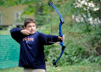 Eleven-year-old Evan Perkins, of Syracuse, releases an arrow after aiming at a target in the archery area.